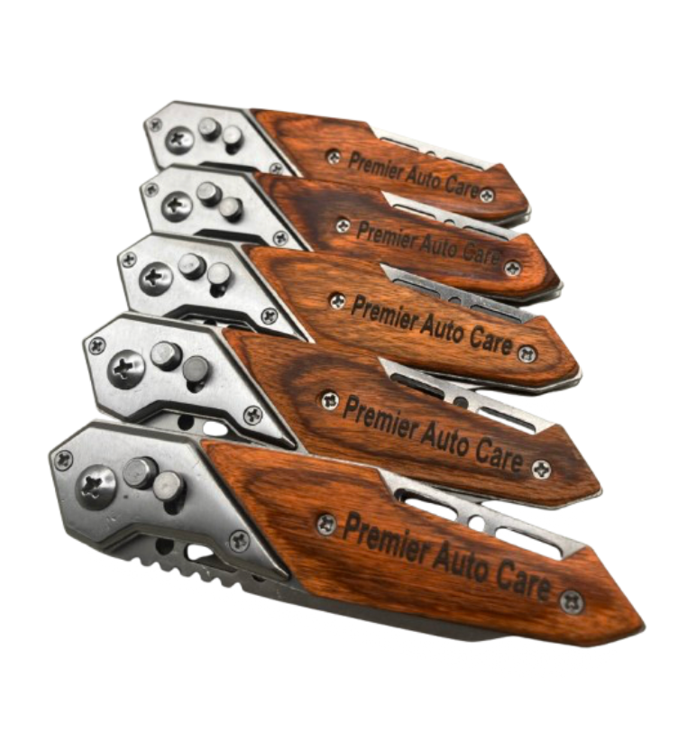 Engraved knife with wood handle, shown closed, designed for a bulk order. The handle features a custom engraving reading 'Premier Auto Care' on it.