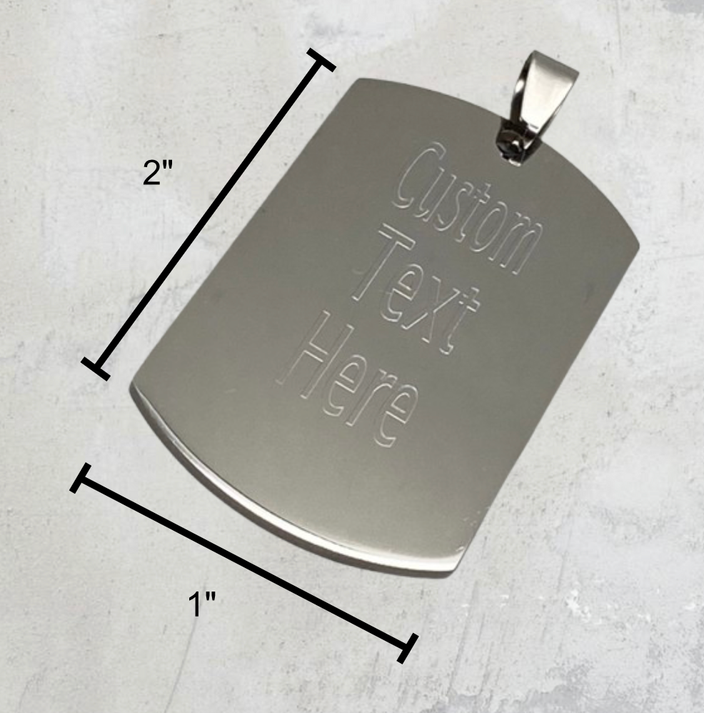 Stainless steel pendant with dimensions labeled: 2 inches tall, 1 inch wide, and 1/16 inch thick.