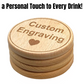 A set of four round wooden coasters with custom engraving, showcasing the text "Custom Engraving" with a heart design below, arranged neatly on a clean background.